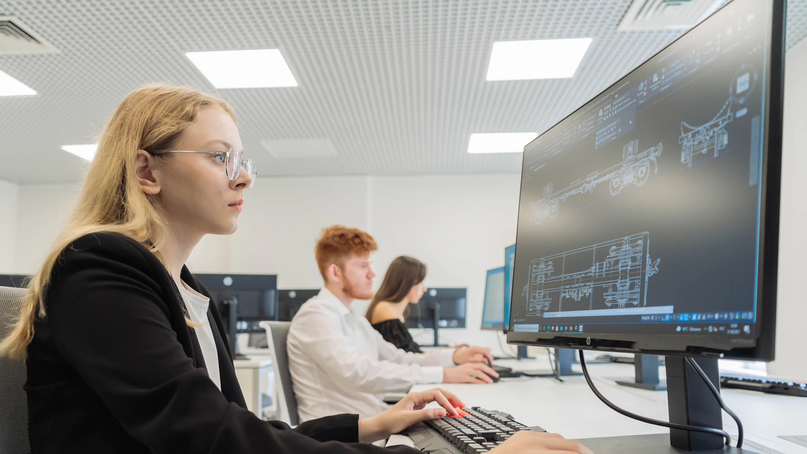 Estudiante realizando un examen digital en un ordenador en un aula de examen